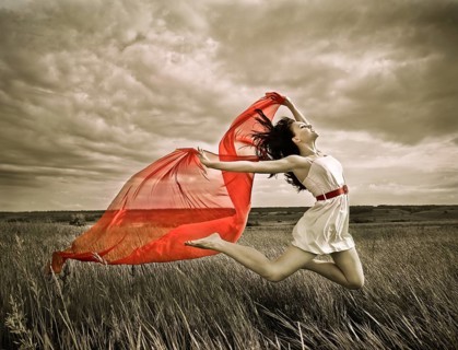 Brunette girl jumping with red fabric in summer day. Outdoors potrait