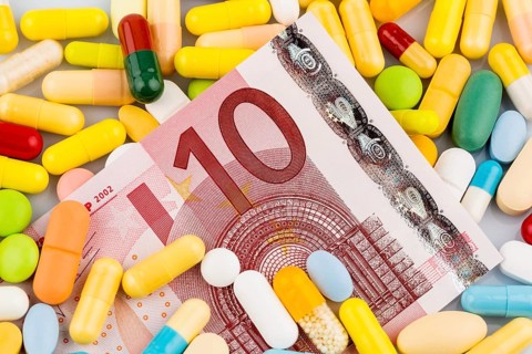 Euro banknotes and tablets, symbolic photo for costs of medication and health insurance. Austria