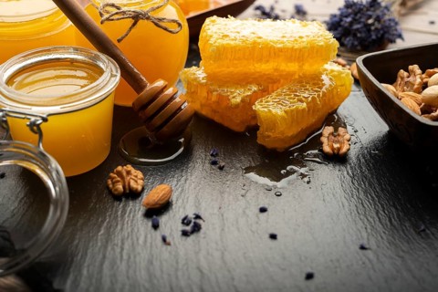 Honeycomb on slate tray with honey and nuts on kitchen table, food photography, food photography