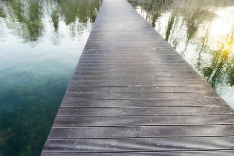 Infinitely long pedestrian bridge over a lake with reflections
