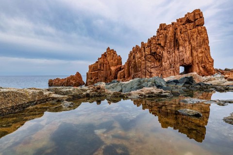 Rocce Rosse, the red rocks of Arbatax are reflected in a tidal pool, Arbatax, Tortoli, Ogliastra,