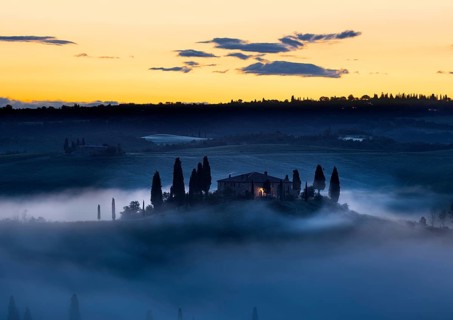 Tuscany farmhouse in morning mist with yellow skies, Val d'Orcia, Italy, Europe