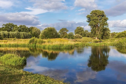 Trave river near Bad Oldesloe in Schleswig-Holstein, Germany, with reflection of the sky and the