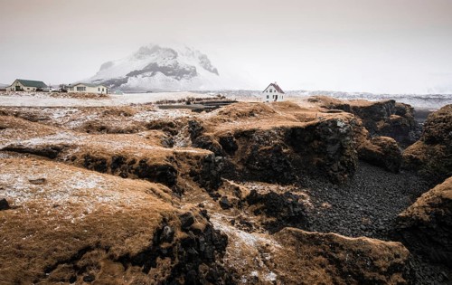 Icelandic landscape with a white small beautiful house in winter under the mountain at Arnarstapi