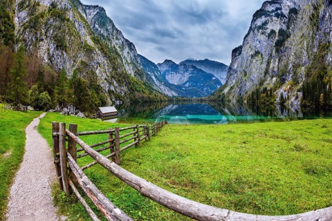 The concept of active tourism and ecotourism. Bavarian Alps. Magic blue lake Obersee and fenced