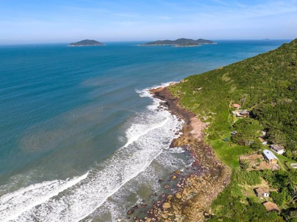 Coastline with beach, mountains and blue ocean with waves in Brazil. Aerial view of Saquinho beach.