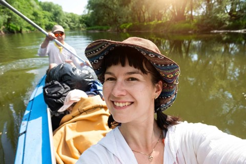 Man and woman couple, baby is sleeping, selfies are happy in family kayak trip rowing boat on the