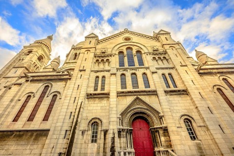 Left side facade and door of Basilique Sacred Heart in Montmartre of Paris in France with no people