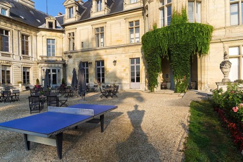 Ping-pong table in the courtyard of the castle Grand Mello. France. Sunny day in August