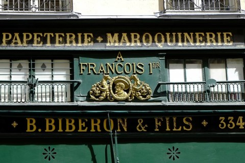 Shop front with golden letters on a green background. Landscape format. Front of a shop with golden