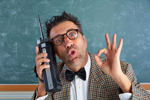 Nerd silly private investigator with retro walkie talkie on teacher balckboard
