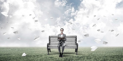 Young businessman or student studying the science and paper planes fly around