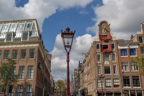 Street lamp in a historic city centre under a blue sky with clouds, Amsterdam, Netherlands