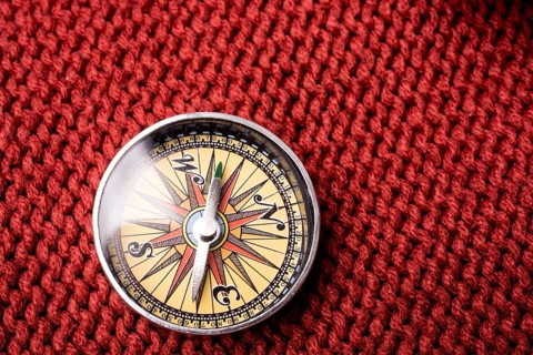Compass tool on red texture fabric