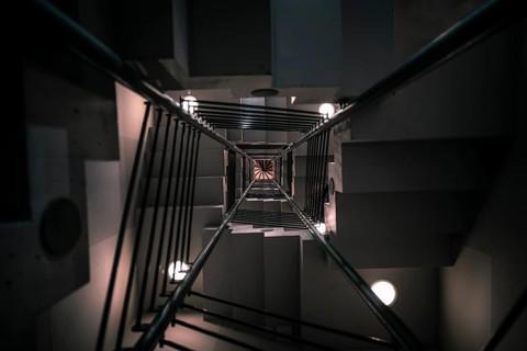 Abstract architectural image with a modern staircase on many levels, viewed from down to up, with