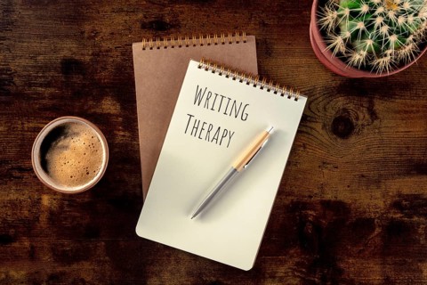 Writing Therapy. Notebook with a pen, coffee, and a plant, overhead flat lay shot on a rustic