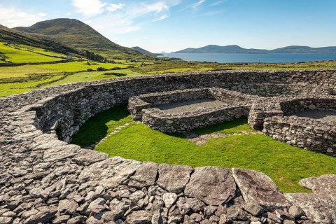 Loher Stone Fort at Caherdaniel overlooking green pastures and the sea under a clear blue sky, Ring