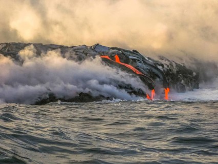 Volcanic activity with smoke and steam given off by lava contact with Pacific Ocean. Kilauea