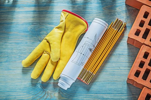 Blueprints safety gloves red bricks wooden meter on wood board bricklaying concept