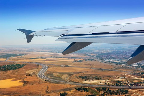 Airplane takeoff from Madrid Barajas over golden wheat fields