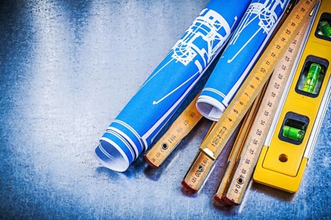 Blue engineering drawings wooden meter construction level on metallic background