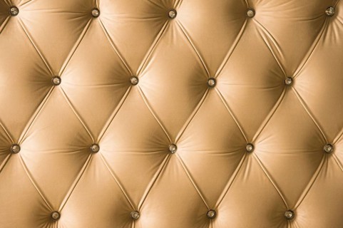 Beige soft textile background with symmetrical buttons on the corners of diamonds. Soft and