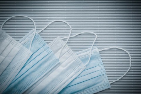 Set of disposable medical flu masks on a striped background