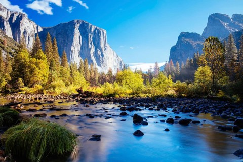 The view from within Yosemite Valley and Northside Drive of surrounding rock faces on a sunny