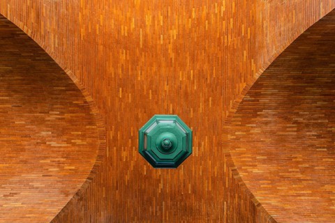 Low angle view of brick vault and green lamp. Directly below view