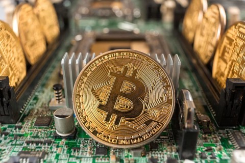 Bitcoin close-up on a computer circuit motherboard as a blockchain technology payment network.