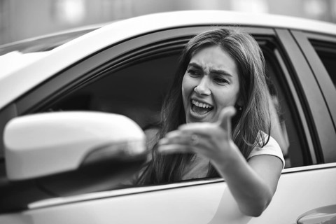 Accident. Young caucasian girl driving a car shocked about to have traffic accident