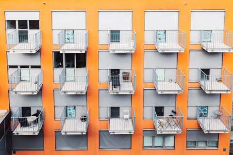 College dorm from outside, view of an orange building with grey balconies. A building where