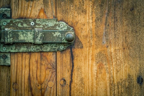 Wooden door from a german stable, with its rusty metal latch and aged wooden planks. Good frame