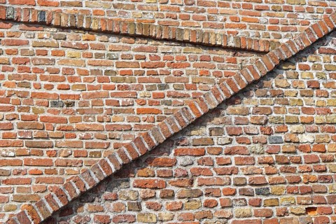 Old red brickwork walls with diagonal lines