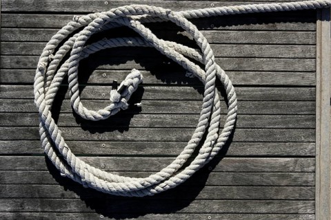 Nautical marine round thread over dried gray teak wood background