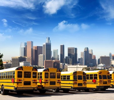 American typical school bus rear view in a row at LA skyline photo mount