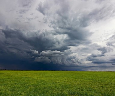 Supercell storm clouds above meadow with green grass Summer Storm clouds