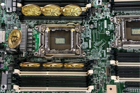 Golden Bitcoin Cryptocurrency on computer circuit board. Blockchain and security concept