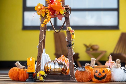 Autumn decor on the porch of the house outside in the yard of pumpkin, lantern, garlands, hats,