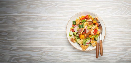 Traditional Levant dish Fattoush salad, Arab cuisine, with pita bread croutons, vegetables, herbs.