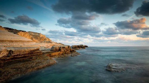 Rocky seashore seascape with wavy ocean and dramatic and beautiful sunset at sea caves coastal area