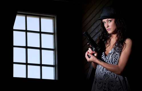 A beautiful police detective woman on the job with a gun
