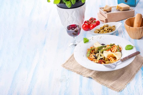 Colourful farfalle with green asparagus olives and parma ham