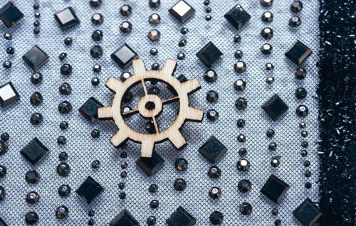 Wooden cogwheels on a fabric industry concept information
