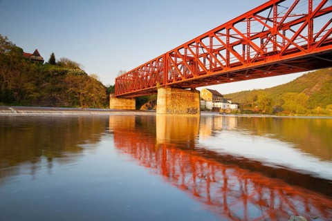 The old iron railway bridge over the river at sunset