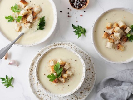 Cauliflower potato soup puree on white marble tabletop, Creamy cauliflower soup with toasted bread