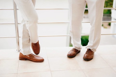The legs of two men standing on the balcony, close-up. The groom and his best man during the