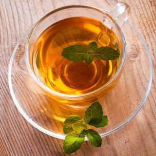 Mint tea in glass cup on wooden table