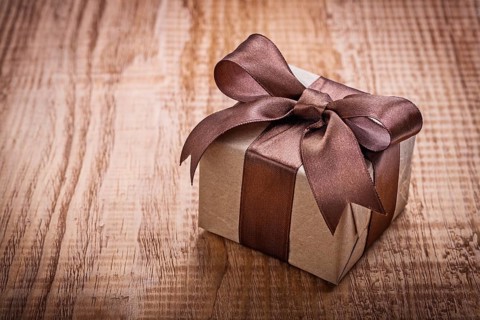 Single square vintage gift box qith brown bow on old wooden board