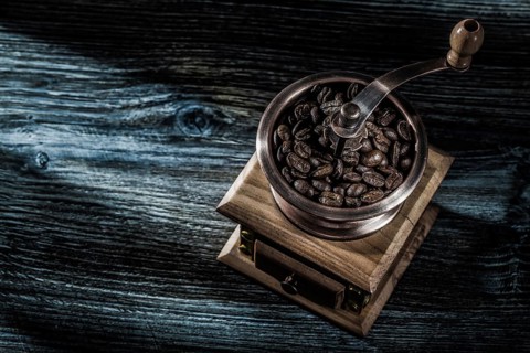 Coffee mill beans on wooden board